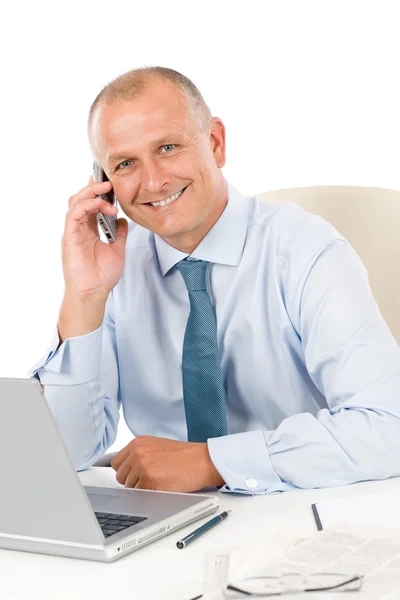 Uomo d'affari sorridente seduto in ufficio dietro la scrivania — Foto Stock
