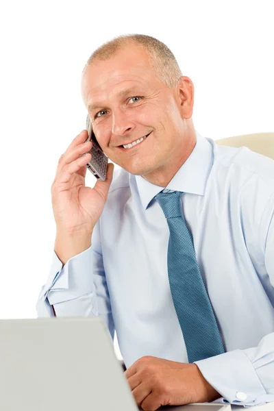 Smiling businessman sitting in office behind desk — Stock Photo, Image
