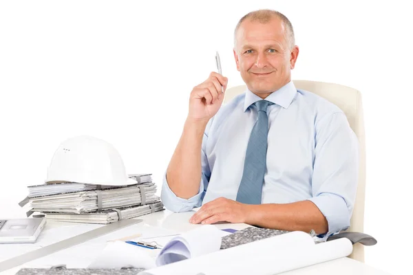 Professional architect with blueprint behind table — Stock Photo, Image
