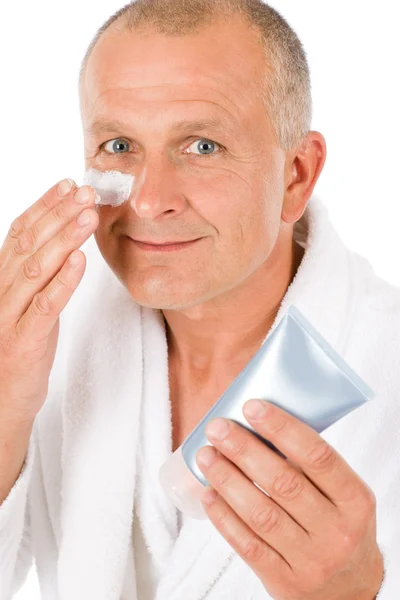 Manliga kosmetika - senior man applicera ansiktskräm — Stockfoto