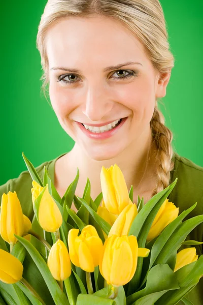 Молодая счастливая женщина держит желтый цветок тюльпанов — стоковое фото
