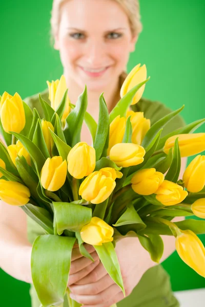 Jonge vrouw houdt geel tulpen bloem — Stockfoto
