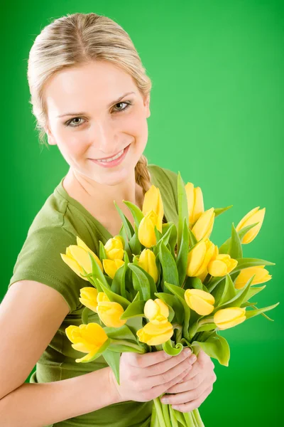 Молодая счастливая женщина держит желтый цветок тюльпанов — стоковое фото