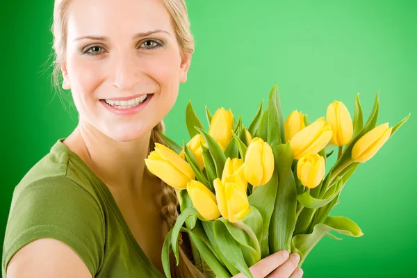 Молода щаслива жінка тримає жовту квітку тюльпанів — стокове фото