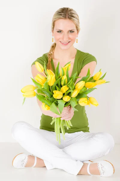 Šťastná žena drží banda tulipány sedí — Stock fotografie