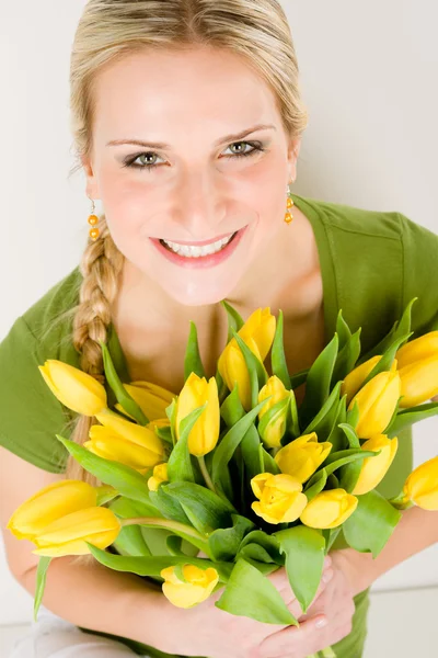 Joven feliz mujer mantenga tulipanes amarillos flor — Foto de Stock