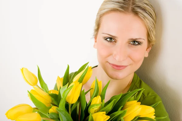 Молода жінка тримає жовту квітку тюльпанів — стокове фото