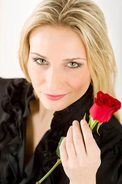 Элегантная блондинка держит красную розу — стоковое фото