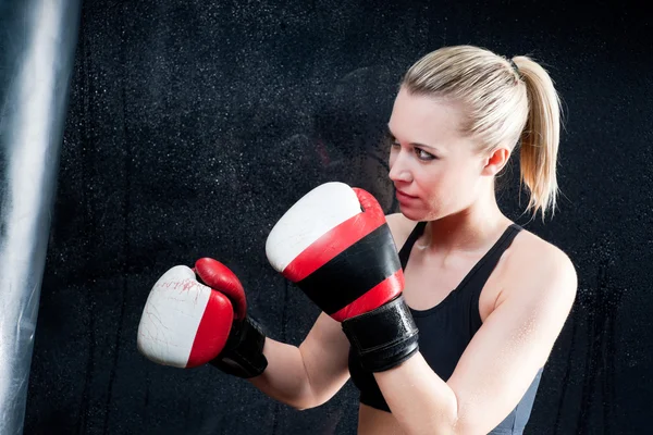Boxerský trénink žena s boxovací pytel v tělocvičně — Stock fotografie