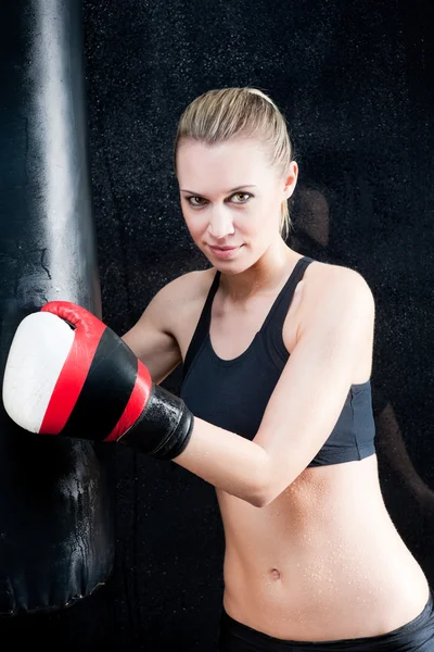 Boxing training woman in black hold punching bag — Stock Photo, Image