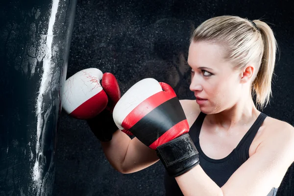 Боксерская тренировочная женщина с боксерской грушей в тренажерном зале — стоковое фото
