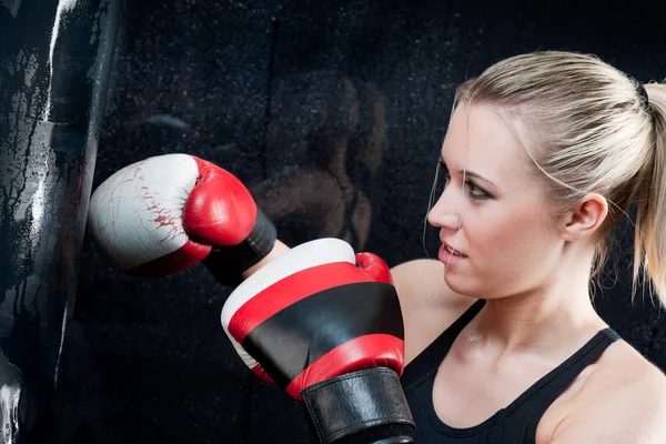Boxeo mujer de entrenamiento con saco de boxeo en el gimnasio — Foto de Stock