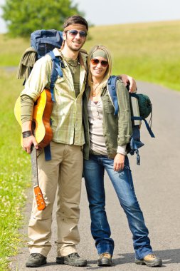 Genç çiftin sırt çantası derbeder asfalt yol hiking