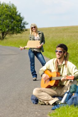 Hitch-hiking young couple backpack asphalt road clipart