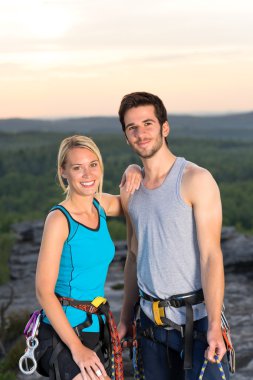 Rock climbing active couple on top sunset clipart