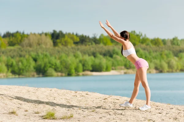 Sommersport Aktive Frau dehnt sich am Strand — Stockfoto