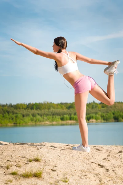 Summer sport fit woman stretching on beach — Stock Photo, Image