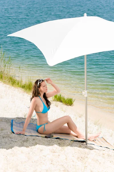 Zomer strand vrouw blauwe bikini onder parasol — Stockfoto