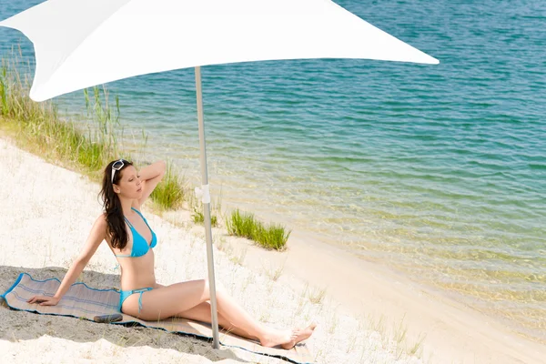 Sommar strand kvinna blå bikini under parasoll — Stockfoto
