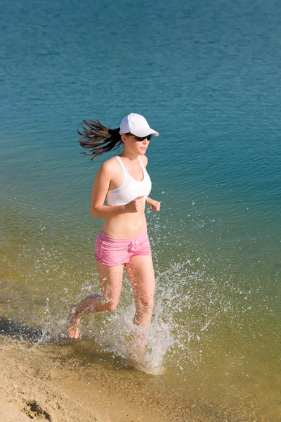Summer sport fit woman jogging along seashore — Stock Photo, Image
