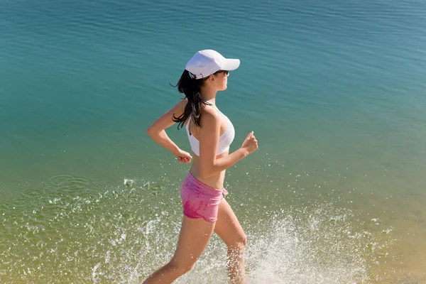 여름 스포츠 맞는 해변을 따라 조깅 하는 여자 — 스톡 사진