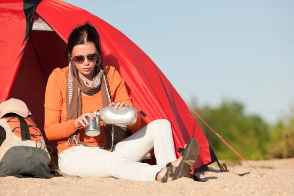 Счастливая женщина, сидящая перед палаткой — стоковое фото