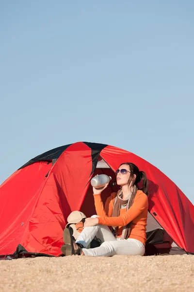 Счастливая женщина, сидящая перед палаткой — стоковое фото