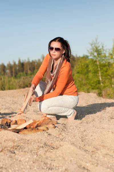 Camping happy woman making campfire on beach — Stock Photo, Image