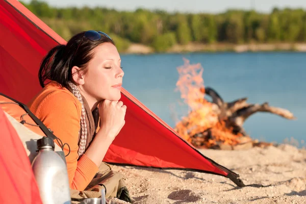 女性はキャンプファイヤーでテントの中でリラックスして幸せなキャンプ — ストック写真