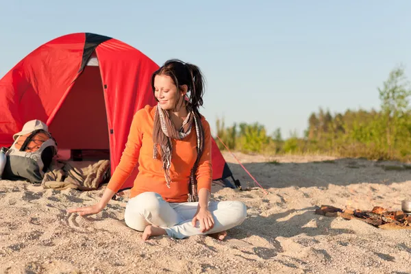 Campeggio felice donna seduta vicino al falò sulla spiaggia — Foto Stock