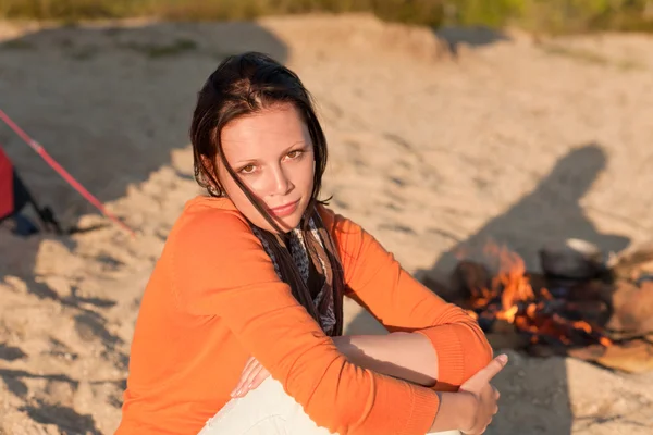 Camping vrouw ontspannen op het strand door kampvuur — Stockfoto
