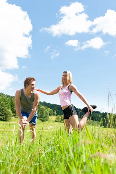 Sportive happy couple in meadows sunny day — Stock Photo, Image