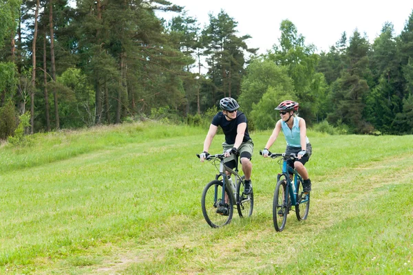 Deporte feliz pareja montando bicicletas en coutryside — Foto de Stock