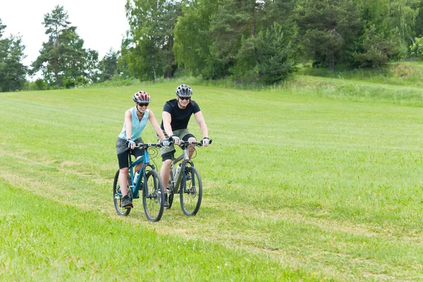 Αθλητισμός ευτυχισμένο ζευγάρι ιππασία ποδήλατα στην τοποθεσία — Φωτογραφία Αρχείου
