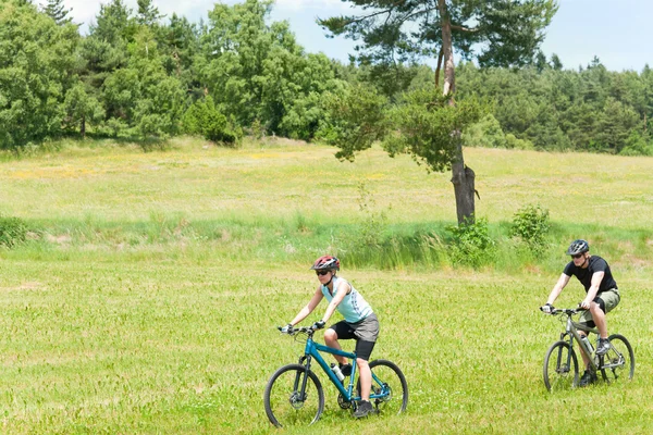 Sport gelukkige paar paardrijden fietsen in platteland — Stockfoto