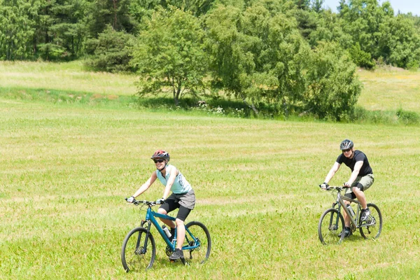 Sport happy couple riding bicycles in coutryside — Stock Photo, Image