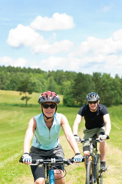 Sport couple riding mountain bicycles in coutryside — Stock Photo, Image