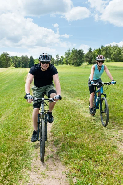 Pareja deportiva montando bicicletas de montaña en coutryside — Foto de Stock