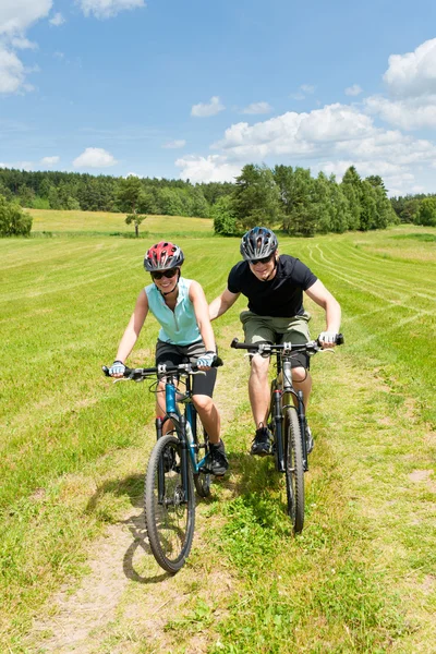 Спортивный горный велосипед - мужчина толкает молодую девушку — стоковое фото