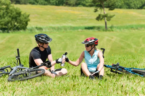 Esporte mountain bike casal relaxar prados ensolarados — Fotografia de Stock