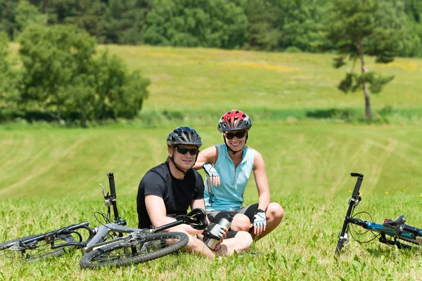 スポーツ山の自転車に乗るカップル リラックス日当たりの良い牧草地 — ストック写真