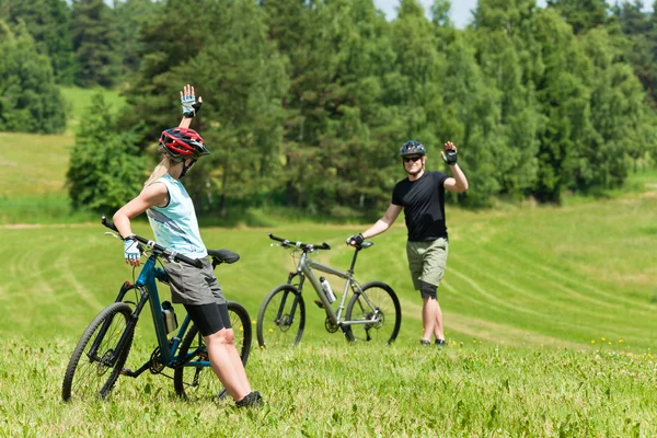 Sport mountain biking couple greeting in meadows — Stock Photo, Image