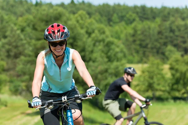 Deporte montaña pareja ciclismo cuesta arriba soleado prados — Foto de Stock