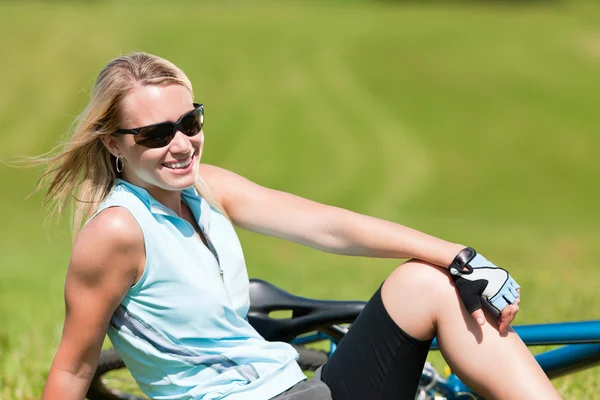 体育山骑自行车的女孩放松在草甸 — 图库照片
