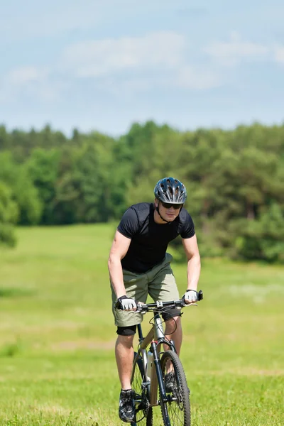 Sportlicher Mann mit Mountainbike auf sonnigen Wiesen — Stockfoto