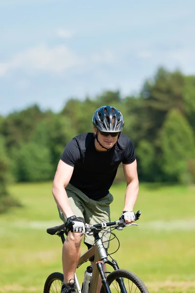 Hombre deportivo bicicleta de montaña cuesta arriba prados soleados —  Fotos de Stock