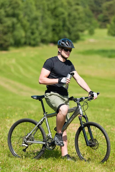 Hombre deportivo bicicleta de montaña relajarse prados soleados — Foto de Stock