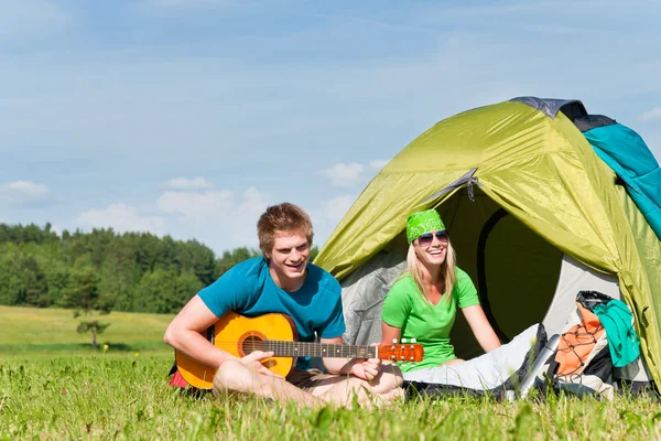 Camping pareja tocando la guitarra por tienda de campaña — Foto de Stock