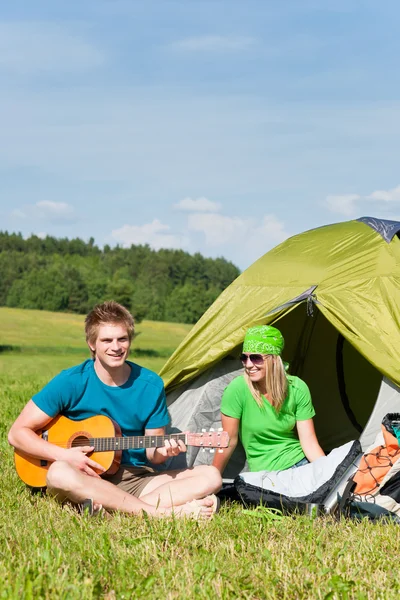 Camping couple playing guitar by tent countryside — Stock Photo, Image