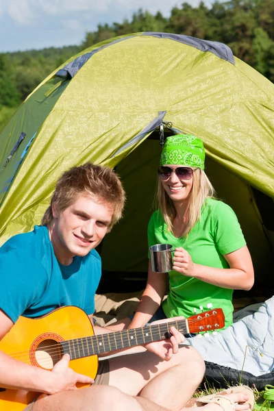 Camping couple playing guitar by tent countryside — Stock Photo, Image